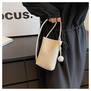 Detail of cream mini crossbody bag with litchi grain leather and woven ball charm