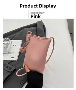Detailed view of pink lychee leather phone bag with knot decorative strap detail
