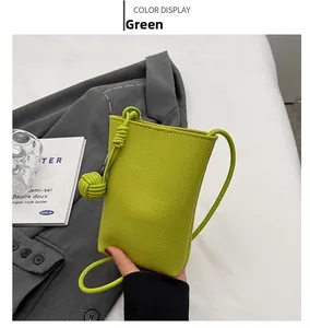 Detail of lime green pebble leather phone bag with drawstring knot and matching strap