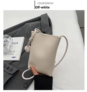 Detail of off-white mini crossbody phone bag with premium lychee grain leather texture
