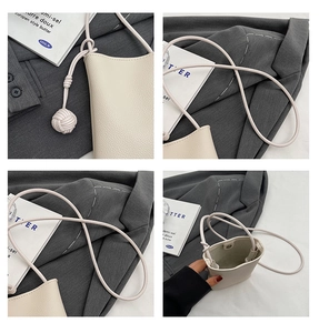 Close-up of litchi grain texture and braided knot detail on a minimalist cream phone bag