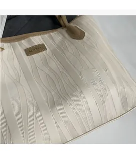 Detailed close-up of cream white tote bag featuring unique 3D wave textured faux leather