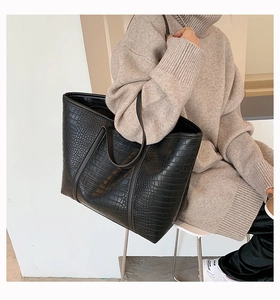 Close-up of the elegant black crocodile pattern texture on this large faux leather tote bag