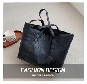 Detailed close-up of large black tote bag featuring premium crocodile pattern embossing