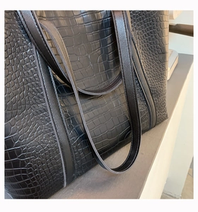 Close-up of black crocodile texture faux leather on a large capacity tote bag