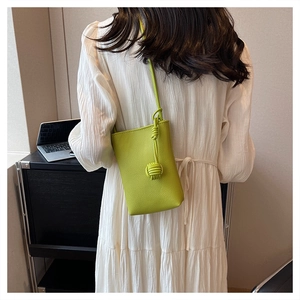 Detailed back view of a grass green mini crossbody bag with litchi texture and knot
