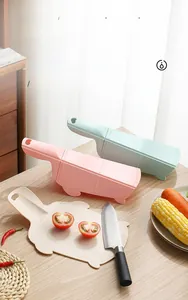 Close-up of foldable kitchen cutting board and drain basket with vegetables on wood surface