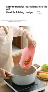 Pink foldable silicone cutting board with funnel design for easy food transfer to pot