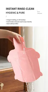 Macro di un tagliere in silicone rosa a forma di tartaruga sciacquato sotto l'acqua corrente