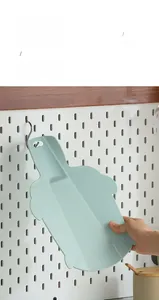 Close-up of portable silicone cutting board in mint green with hanging hole design