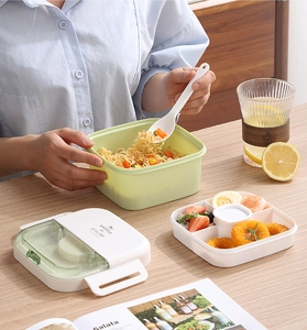 Detailed layered view of a dual-layer bento box with green base and white compartments