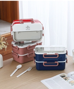 Detail of double-layer lunch box featuring folding handle, secure buckles and utensils