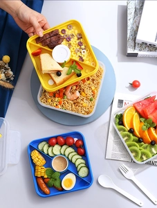 Detail of multi-compartment lunch box with central sauce container for food prep