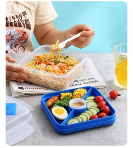 Divided lunch box with blue tray showing compartmentalized salad and meal prep contents