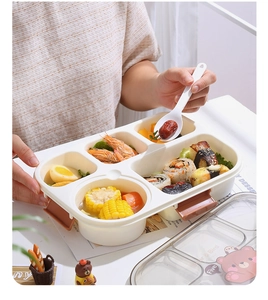 Detail view of a 5-compartment bento box with cartoon bear lid and white plastic spoon