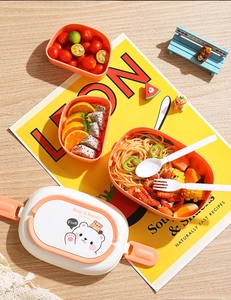 Close-up of the orange dual-layer lunch box with bear pattern and compartmentalized tiers