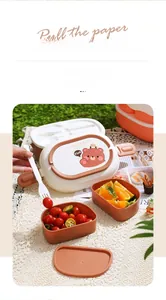 Detail view of a multi-layer bear bento box set with orange compartments and white fork