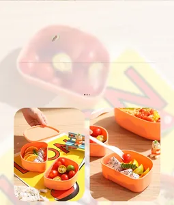 Detail view of double-layer lunch box with compartments showing pasta and fresh fruits
