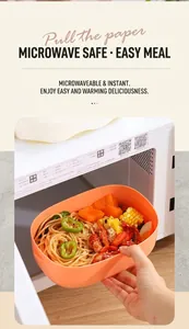 Orange plastic lunch box with pasta being placed into a microwave oven for heating