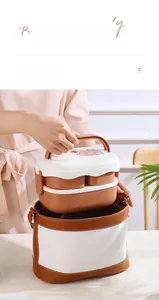 Double-layer bear lunch box being placed into a matching brown insulated carry bag