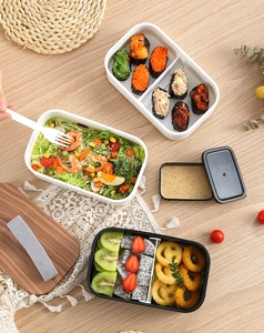 Top view of double-layer lunch box with wood-textured lid and elastic strap detail