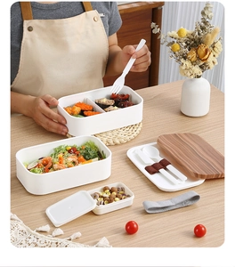Close-up of minimalist double-layer lunch box with wood grain lid and cutlery set