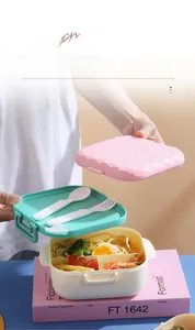 Detail view of multi-layered lunch box with compartments and built-in utensil storage