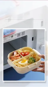 Three-compartment bento box shown being used for microwave heating with side handles