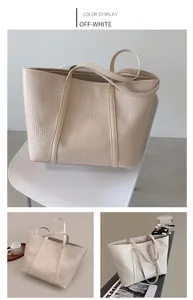 Detail of cream white tote bag with crocodile embossed leather and minimalist top handles