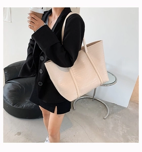 Chic beige tote bag with crocodile texture shown in a minimalist Nordic interior setting
