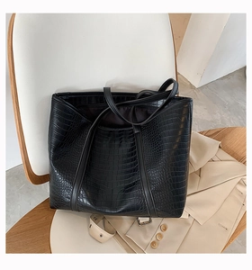 Close-up of black crocodile-embossed tote bag featuring a high-capacity minimalist design
