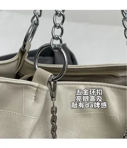 Détail du sac en cuir grainé blanc cassé avec chaîne argentée épaisse et anneau brillant