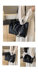 Détail du sac cabas matelassé noir avec chaîne argentée et accents de perles élégantes