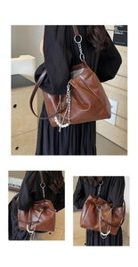 Détail d'un sac seau en cuir PU marron avec breloque perle et chaîne en argent