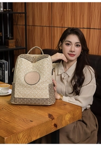 Detailed view of a retro beige and brown monogrammed backpack with leather patch logo