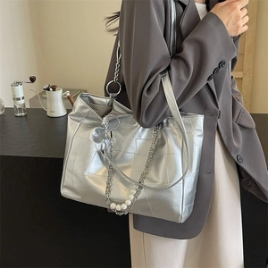 Sac fourre-tout argenté métallisé avec surpiqûres et chaîne de perles sur modèle