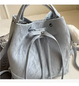 Close-up of mint green bucket bag with drawstring closure and marble texture detail