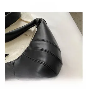 Macro detail of the black leather quilted stitching on this crescent-shaped bag