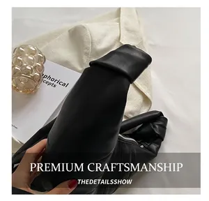 Nahaufnahme der schwarzen Leder-Croissant-Tasche mit geknotetem Riemen und Silberreißverschluss
