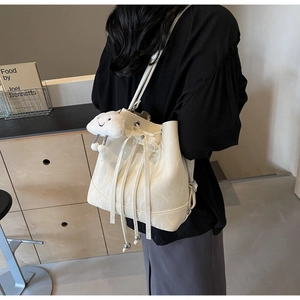 Detail of off-white bucket bag with marble texture and cloud charm on a model