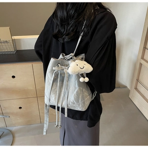 Detail of light gray pleated bucket bag with cloud pendant worn by a model