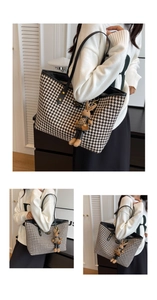 Detail of houndstooth tote bag featuring a cute rabbit charm and leather shoulder straps