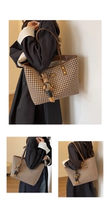 Detail view of houndstooth tote bag with brown leather trim and cute rabbit charm