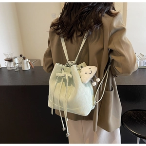 Detail of mint green drawstring bucket bag with pleated leather and cloud charm accessory
