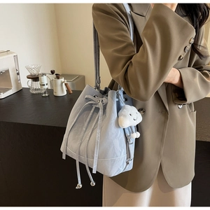 Detail of light blue bucket bag with ripple texture and cute white cloud pendant