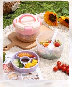 Détail d'une boîte à lunch rose avec plateaux divisés et bol à salade pour le bureau