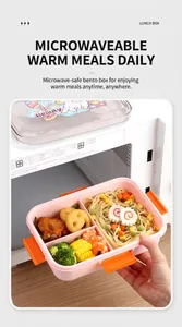 Pink 3-compartment lunch box filled with pasta and shrimp inside a microwave