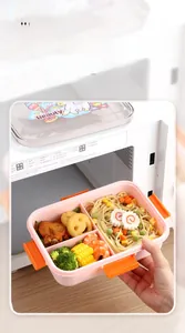 Pink 3-compartment lunch box filled with pasta and shrimp inside a microwave