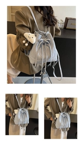 Detail of light blue bucket backpack with crushed pleat texture and plush cloud charm