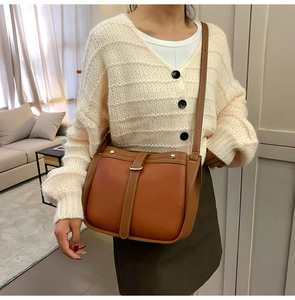 Detail of vintage brown saddle bag with metal buckle and textured leather finish